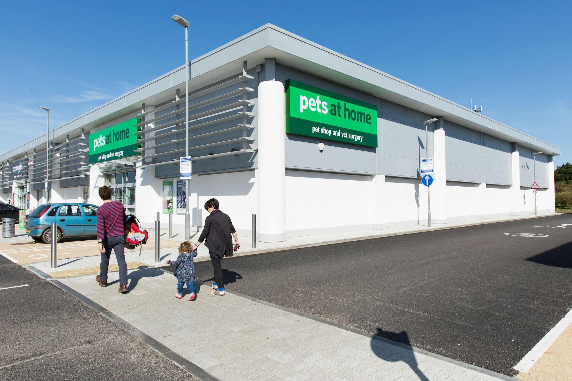 large store front with signage on render finish to bottom of facade and steel panelling to top